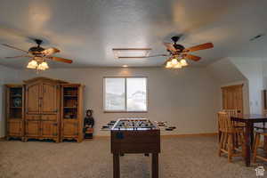 Game room with light carpet, ceiling fan, and a textured ceiling