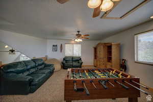 Playroom featuring ceiling fan, carpet floors, and a textured ceiling