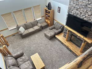 Carpeted living room with a stone fireplace and a textured ceiling