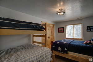 Bedroom featuring carpet flooring and a textured ceiling