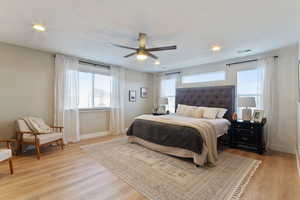 Bedroom with ceiling fan and light hardwood / wood-style flooring