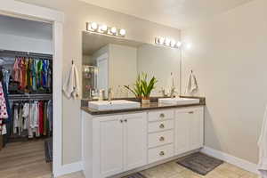 Bathroom with tile patterned floors, vanity, and a textured ceiling