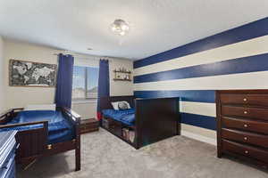 Carpeted bedroom featuring a textured ceiling