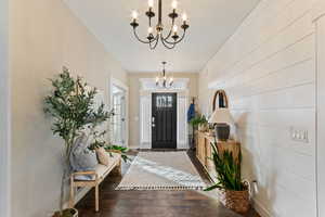 Entryway featuring dark hardwood / wood-style floors and a chandelier