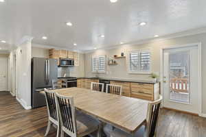 Dining room featuring a textured ceiling, dark hardwood / wood-style flooring, ornamental molding, and sink