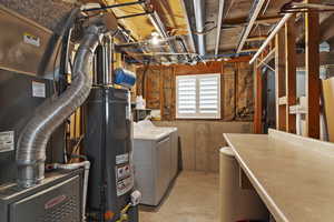 Basement featuring heating unit, gas water heater, and independent washer and dryer