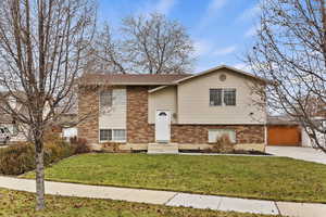 Split foyer home with a front yard and a garage