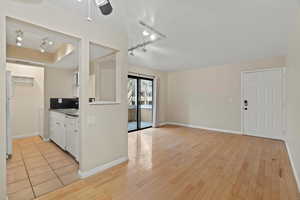 Kitchen featuring white cabinetry, sink, ceiling fan, light hardwood / wood-style floors, and white appliances