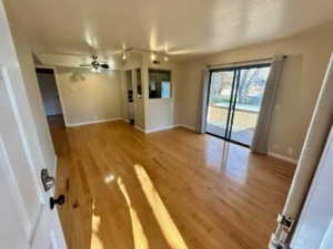 Unfurnished living room featuring ceiling fan and hardwood / wood-style floors