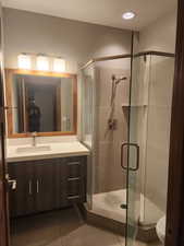 Guest bathroom featuring toilet, vanity, tile patterned floors, and walk in shower