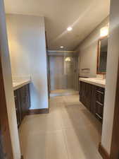 Master Bathroom with his & hers vanity, tile patterned floors, and an enclosed toilet and shower