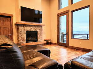 Living room with wood flooring and a stone fireplace