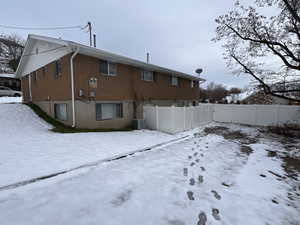 Snow covered property featuring central AC unit