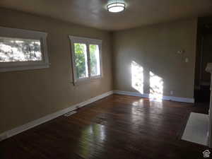 Empty room featuring dark hardwood / wood-style flooring