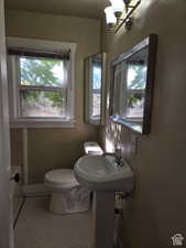 Bathroom featuring sink, tile patterned flooring, an inviting chandelier, and toilet