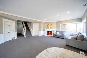 Living room featuring dark colored carpet and crown molding