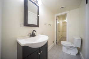 Bathroom featuring tile patterned floors, vanity, and toilet