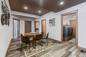 Dining area with wood-type flooring and washing machine and clothes dryer