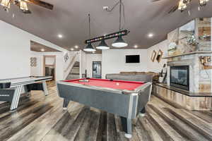 From basement french doors, enter into the family room featuring pool table, air hockey, and gas fireplace.