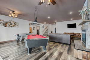 From basement french doors, enter into the family room featuring pool table, air hockey, and gas fireplace.