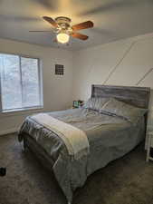 Bedroom featuring dark colored carpet, a textured ceiling, and ceiling fan