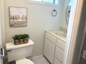 Bathroom featuring tile patterned flooring, vanity, and toilet