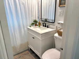 Updated bathroom with a shower with curtain, vanity, and toilet