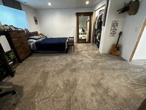 partially finished basement bedroom with carpet floors and a closet.