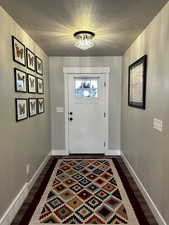 Entrance foyer with dark hardwood / wood-style flooring, and a baseboard heating unit