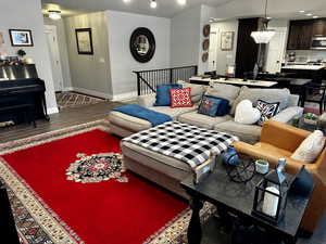 Back upstairs, living room featuring hardwood / wood-style floors, a chandelier, and track lighting