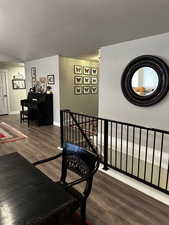 Stairs downstairs featuring hardwood / wood-style floors and a textured ceiling