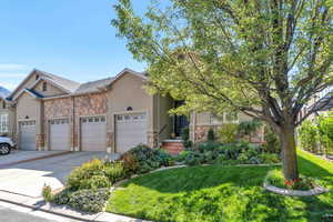 View of front facade featuring a front yard and a garage