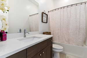 Full bathroom featuring vanity, toilet, and shower / bathtub combination with curtain