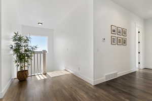 Corridor with dark hardwood / wood-style flooring