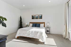 Bedroom featuring light carpet