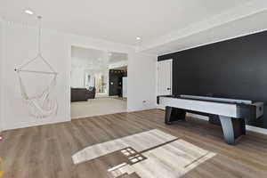 Game room with light hardwood / wood-style floors