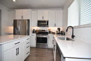 Kitchen quartz countertops., white cabinets, and stainless-steel appliances