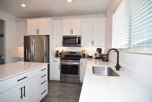 Kitchen with white cabinets, sink, and stainless steel appliances