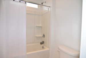 Bathroom featuring shower / tub combo and toilet