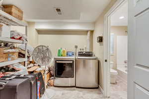 Laundry room with light tile patterned flooring and independent washer and dryer