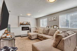 Carpeted living room featuring plenty of natural light and a textured ceiling