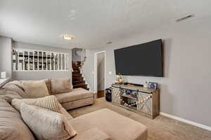 Carpeted living room featuring a textured ceiling