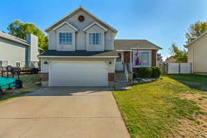 View of front of house featuring a front yard and a garage