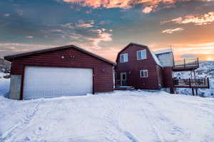 View of front of property featuring an outbuilding, a balcony, and a garage