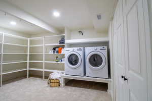 Clothes washing area with light carpet and washing machine and clothes dryer