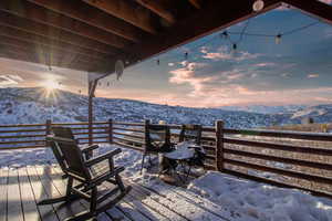 Snow covered deck with a mountain view