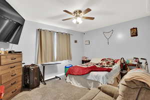 Bedroom featuring ceiling fan and carpet floors