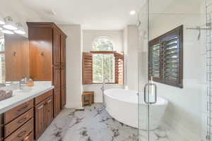 Bathroom featuring vanity and independent shower and bath