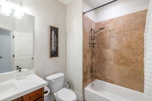 Full bathroom featuring vanity, toilet, and shower / bathtub combination with curtain