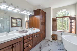 Bathroom featuring separate shower and tub and vanity